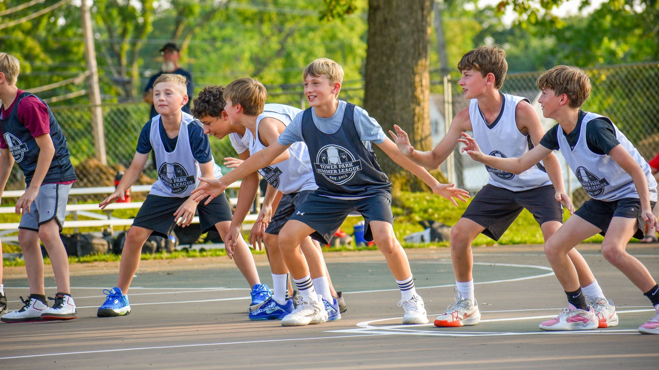 Boys in basketball jerseys running a drill