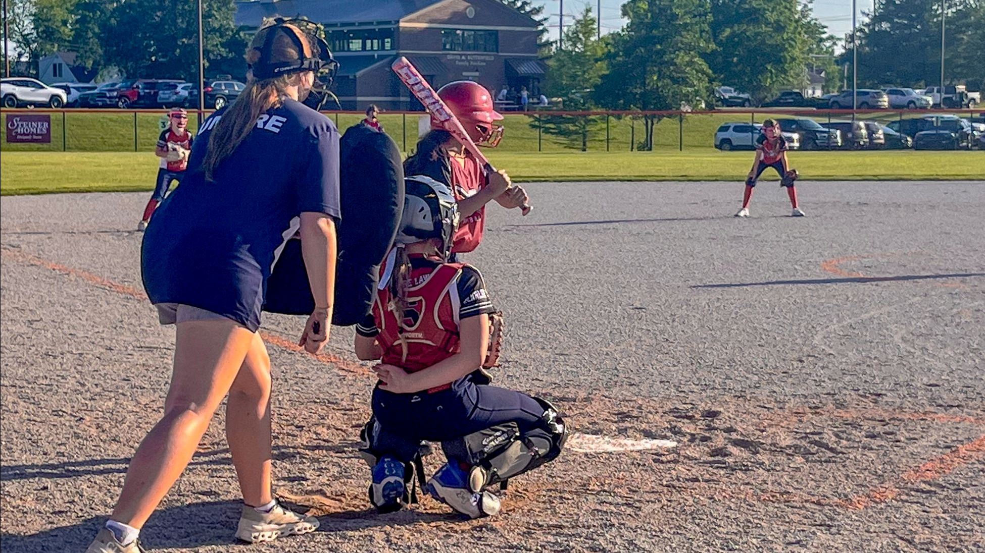 A softball player, catcher, and umpire at home plate